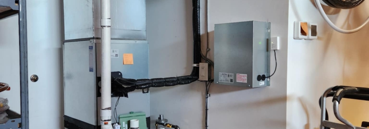 Indoor Lennox furnace and duct system installed by ServiceXEL, with visible ventilation, pipes, and control panel